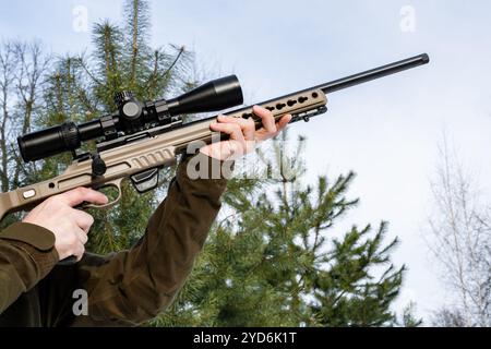 A sniper rifles from a rifle with an optical sight in man`s hands winter day Stock Photo